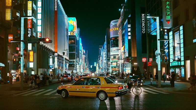 Nighttime city street with taxi
