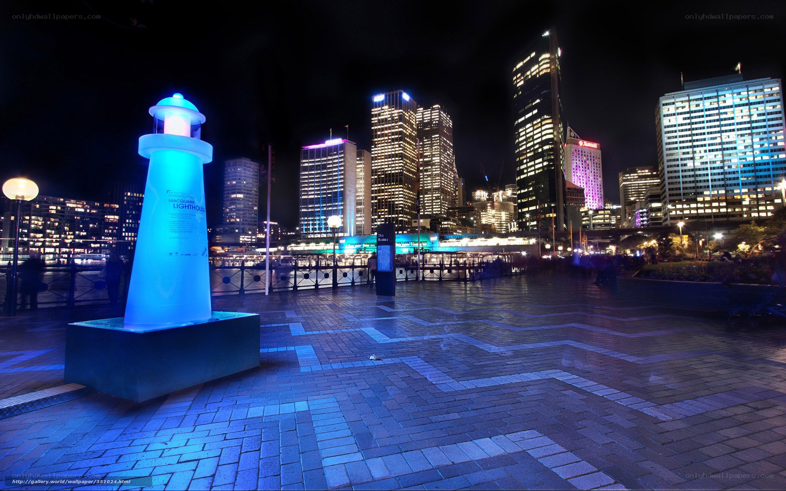 Nighttime city with lighthouse sculpture