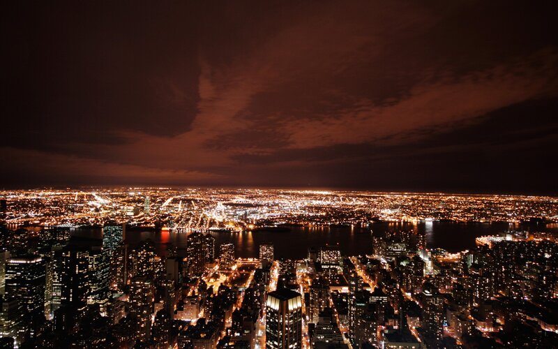 Nighttime Cityscape View — Black, Dramatic, Night, Photograph, Skyscrapers, River, Lights, Clouds, Orange, Yellow