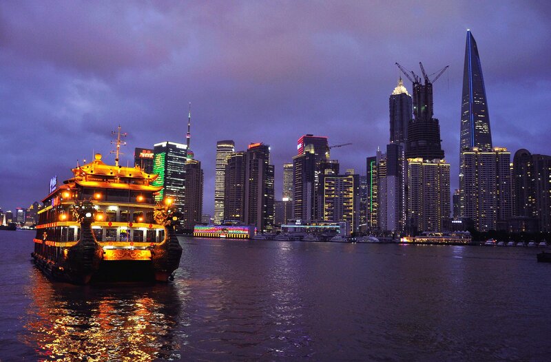 nighttime cityscape with illuminated boat