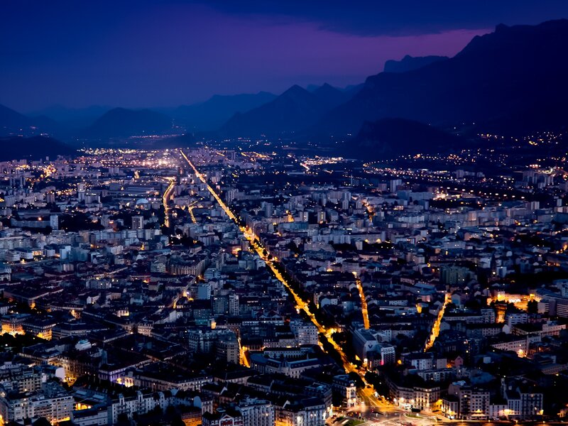nighttime cityscape with mountains