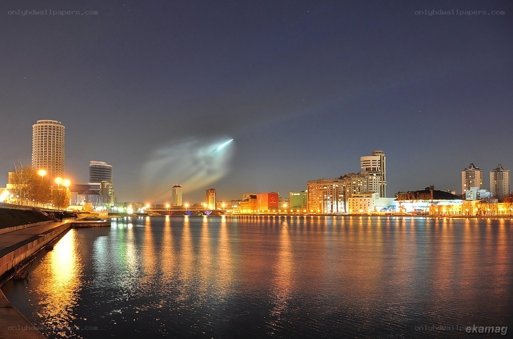 Nighttime cityscape with rocket launch