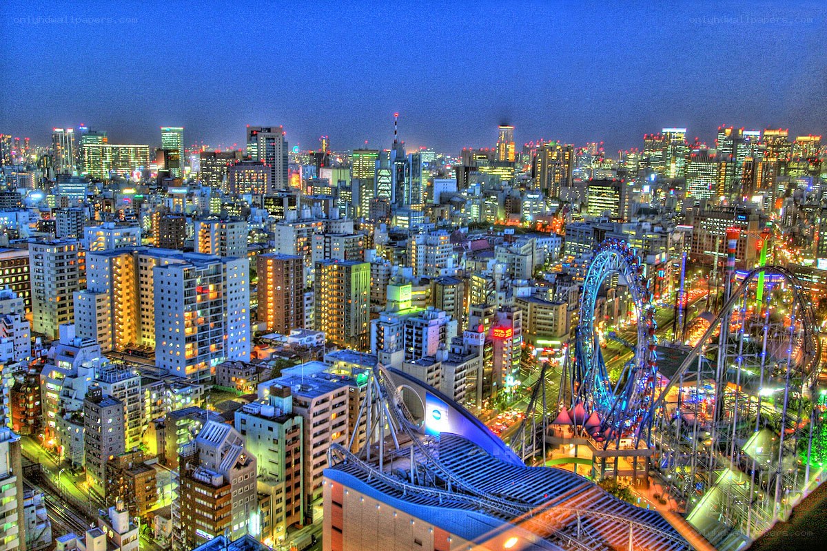 nighttime cityscape with roller coaster