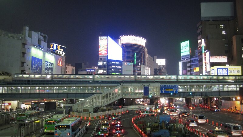 nighttime cityscape with train and traffic