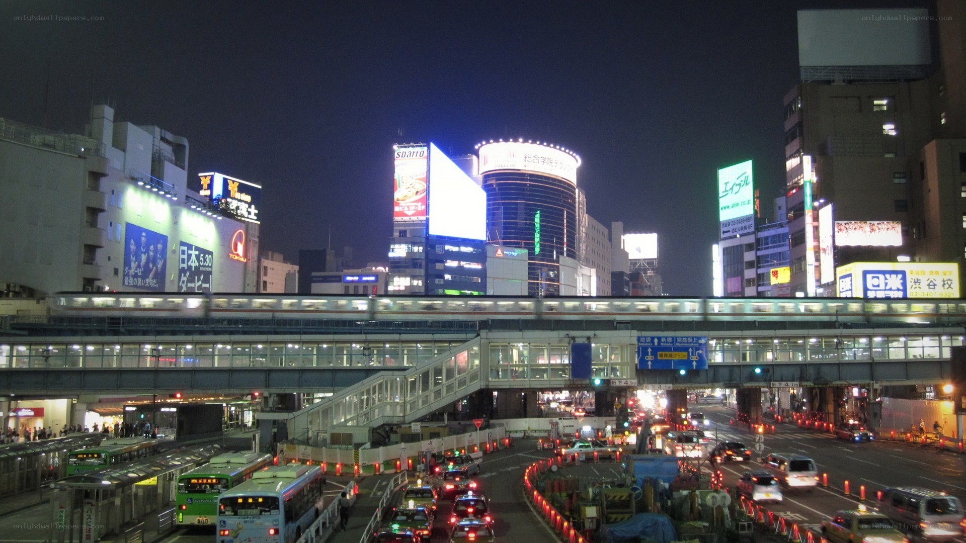 nighttime cityscape with train and traffic