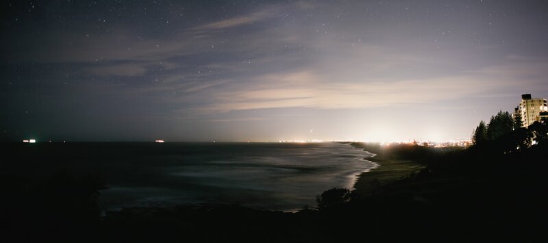 nighttime coastal view with city lights