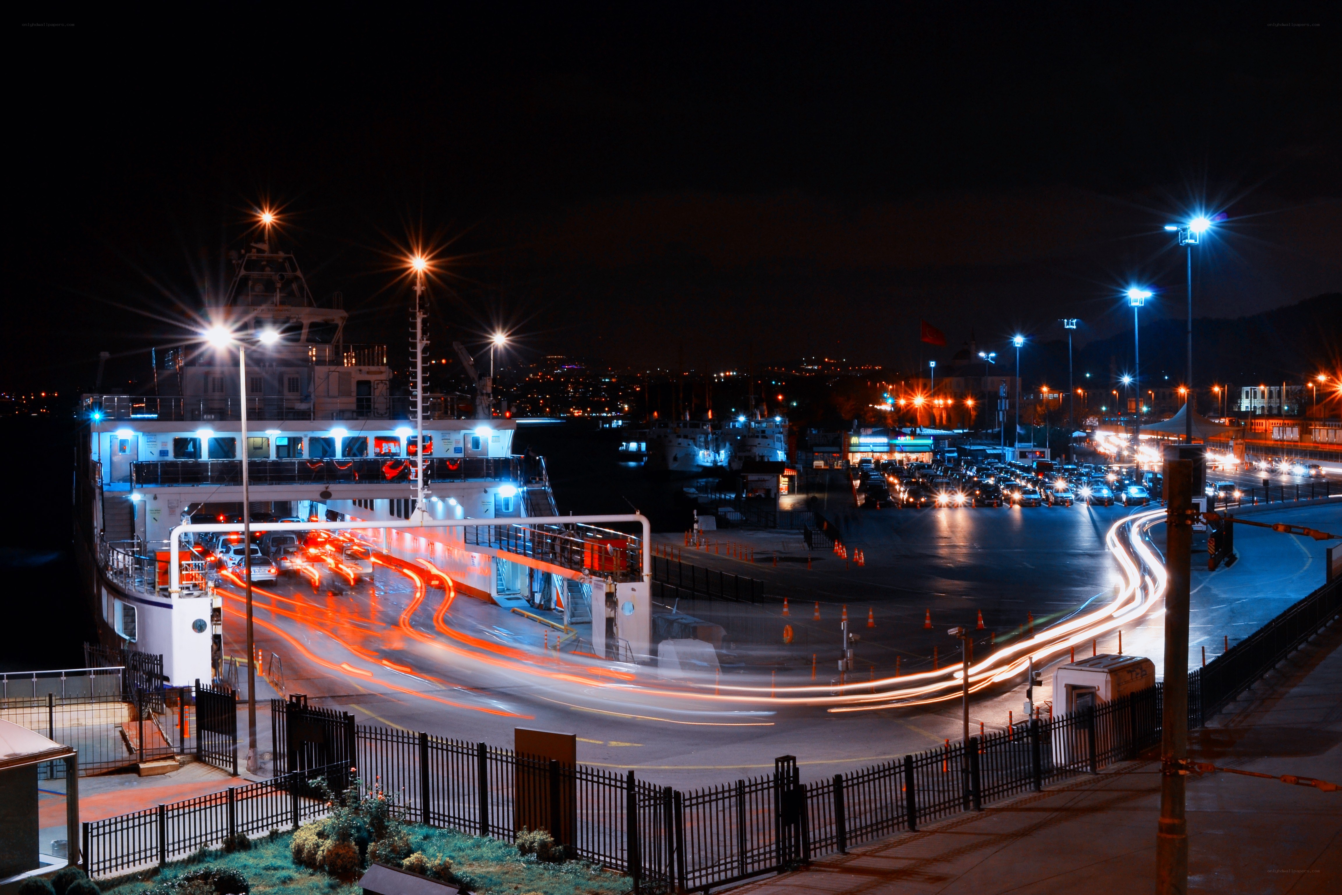 Nighttime ferry port with light trails
