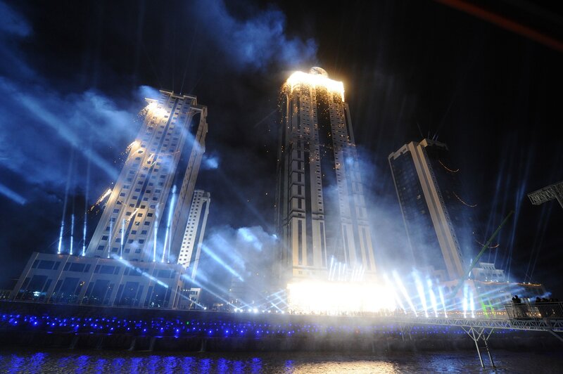 Nighttime fireworks over city buildings
