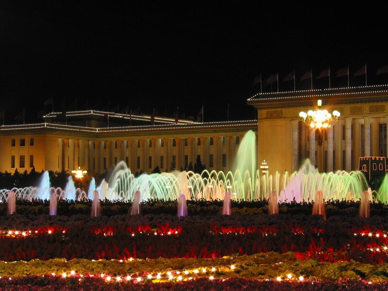 Nighttime fountain display at a grand building