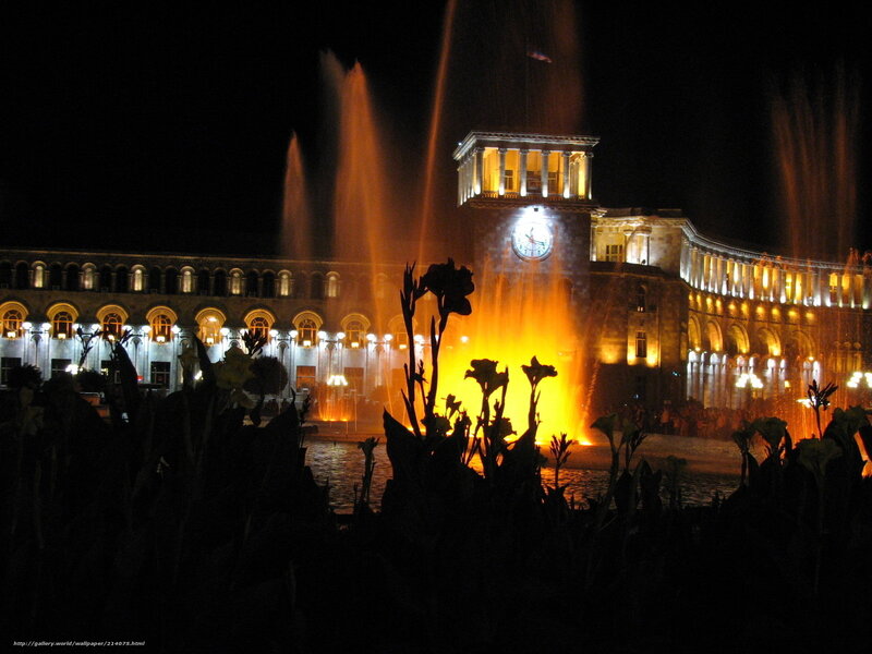 Nighttime fountain display at a grand building