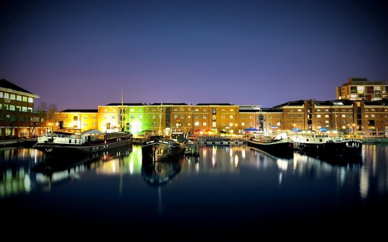 nighttime harbor with boats and buildings