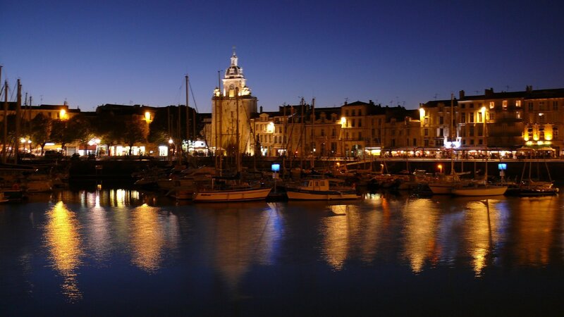 nighttime harbor with clock tower