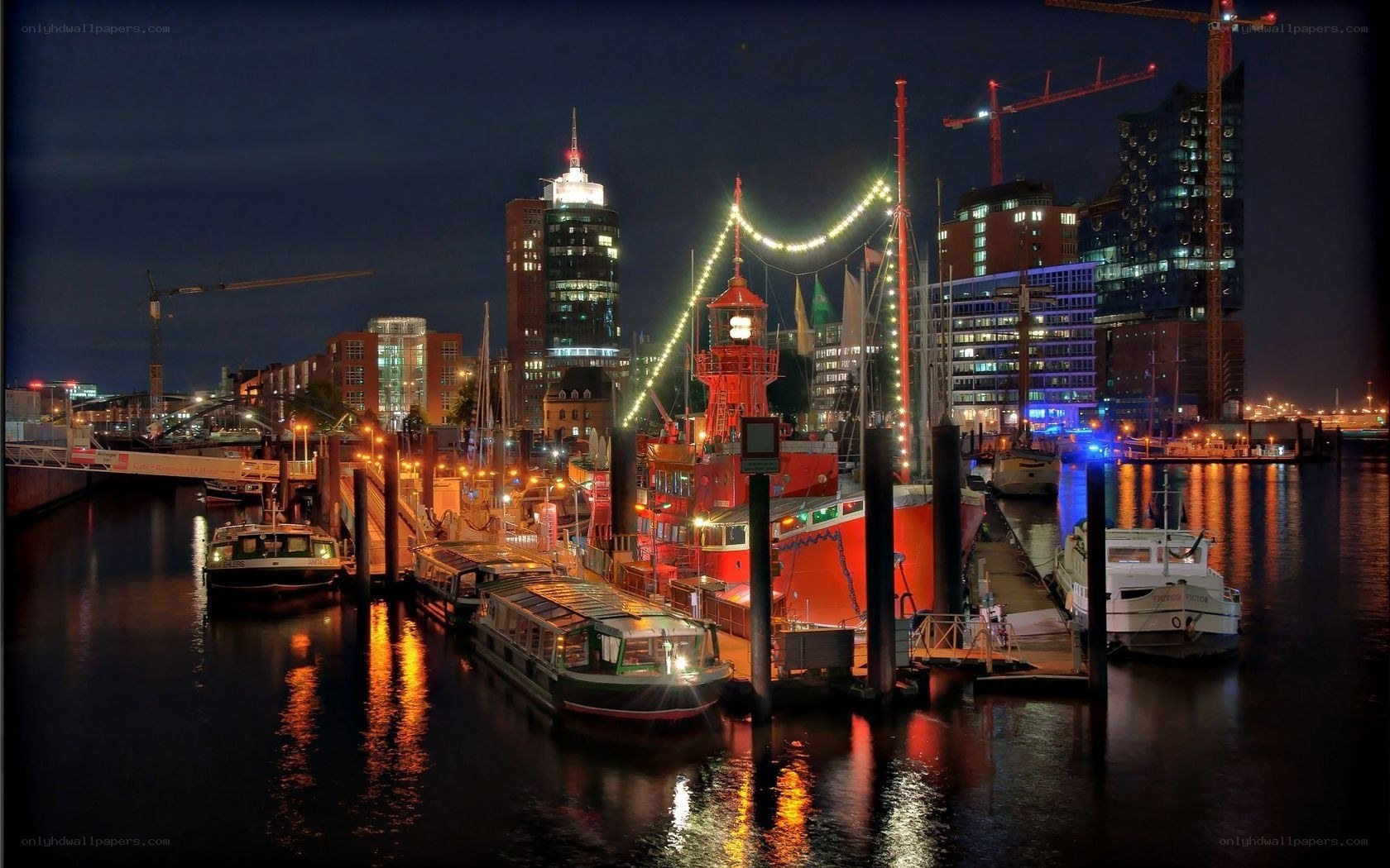 nighttime harbor with illuminated boats