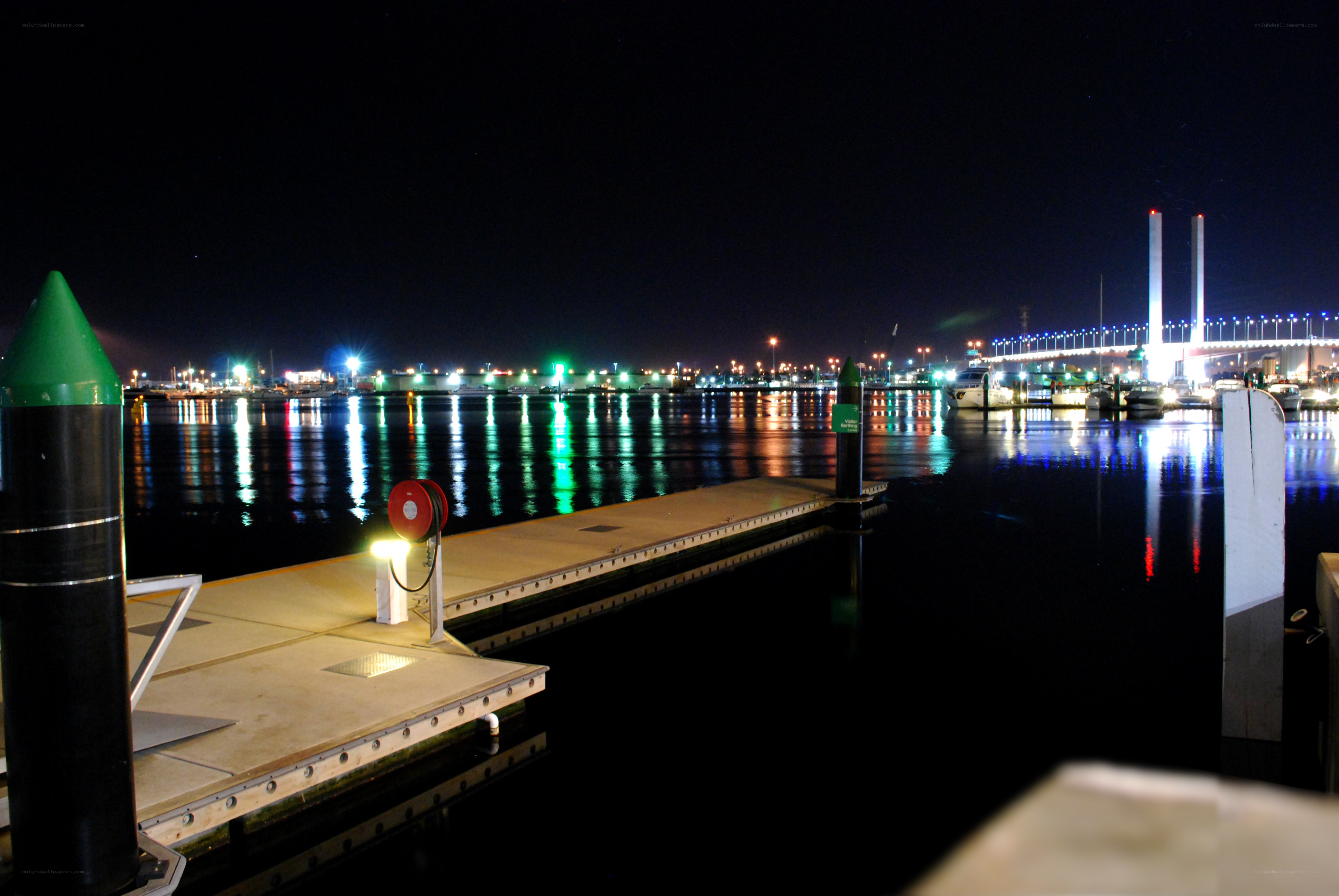 Nighttime harbor with illuminated bridge