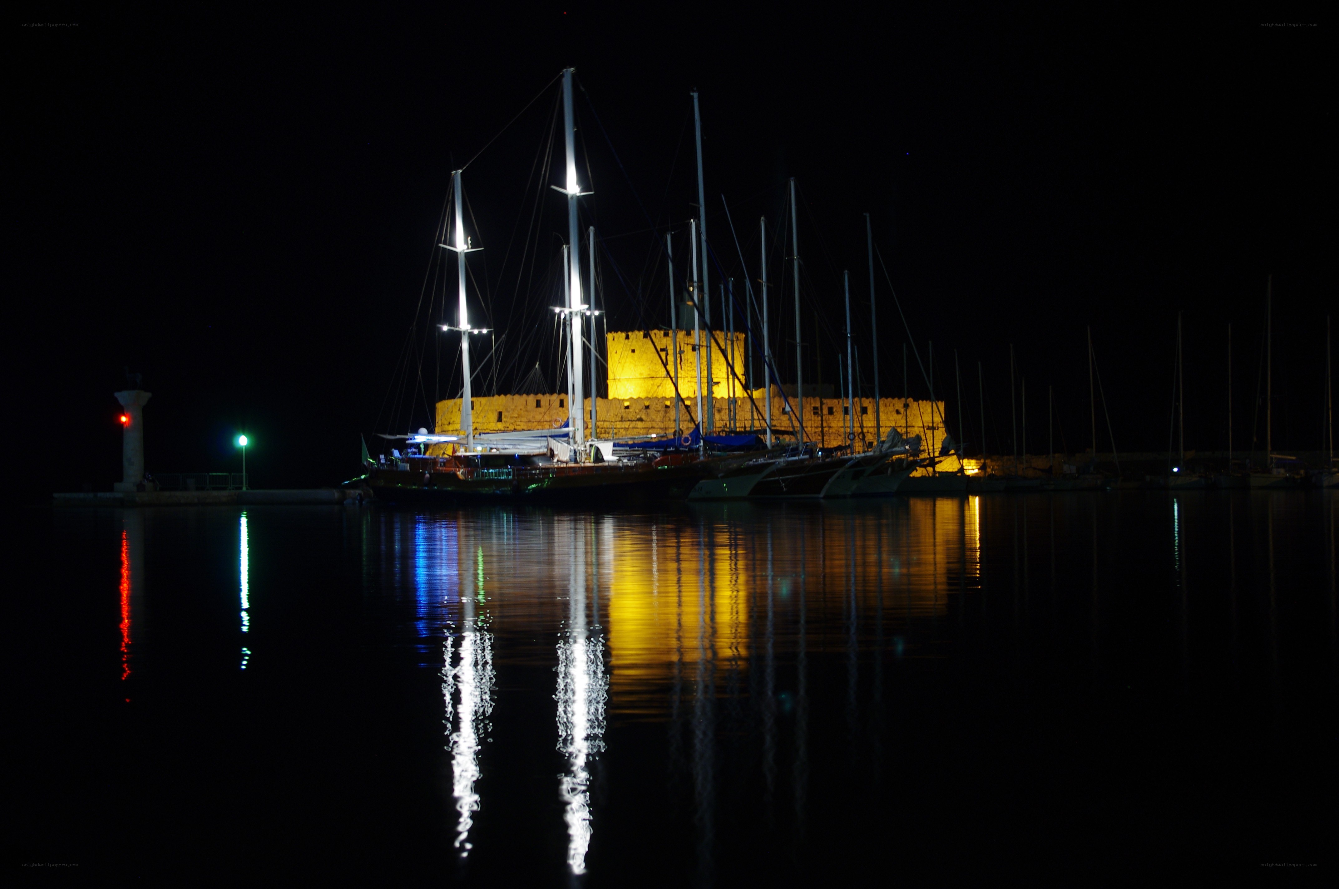 Nighttime harbor with illuminated castle