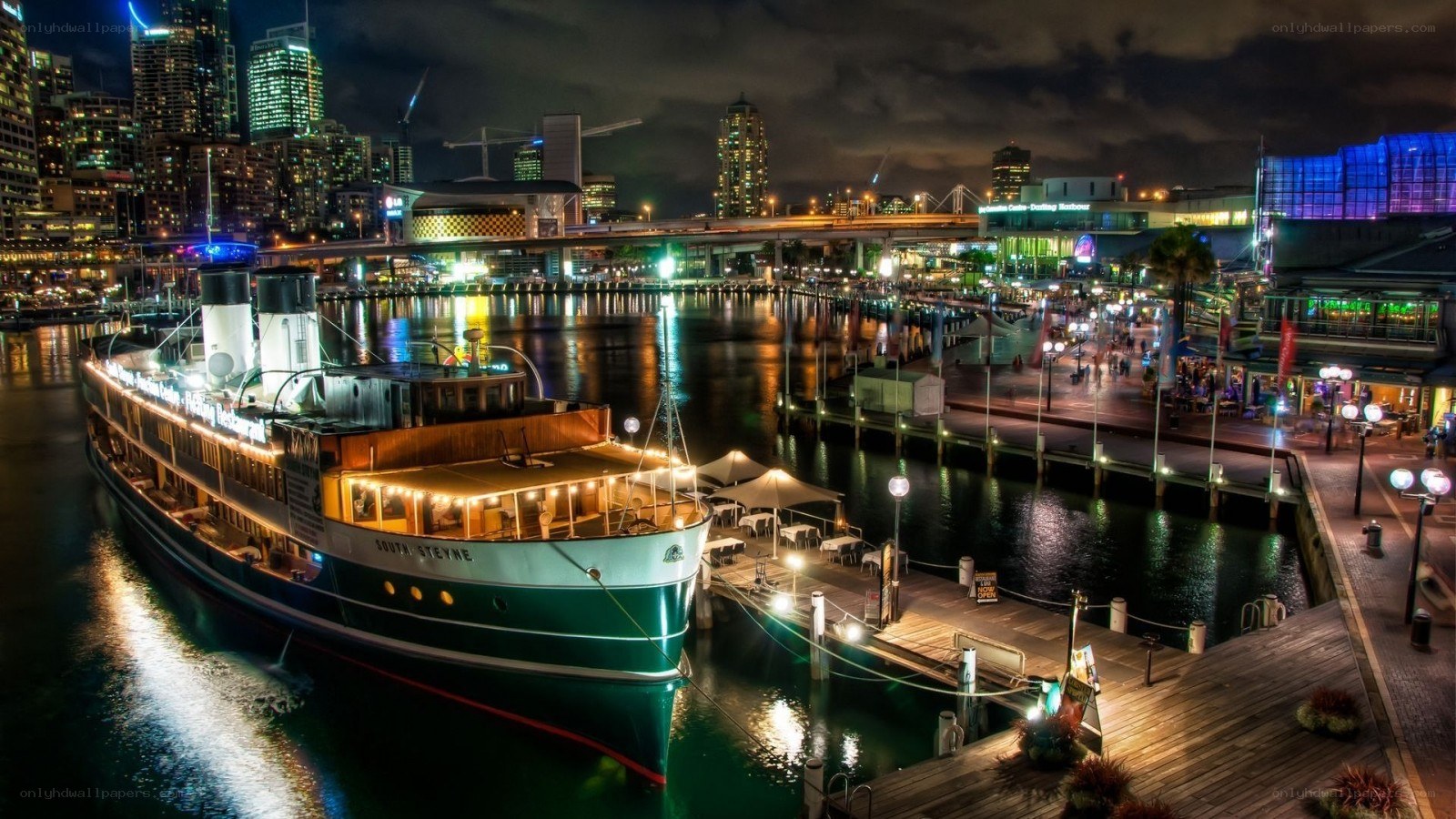 nighttime harbor with ship and city