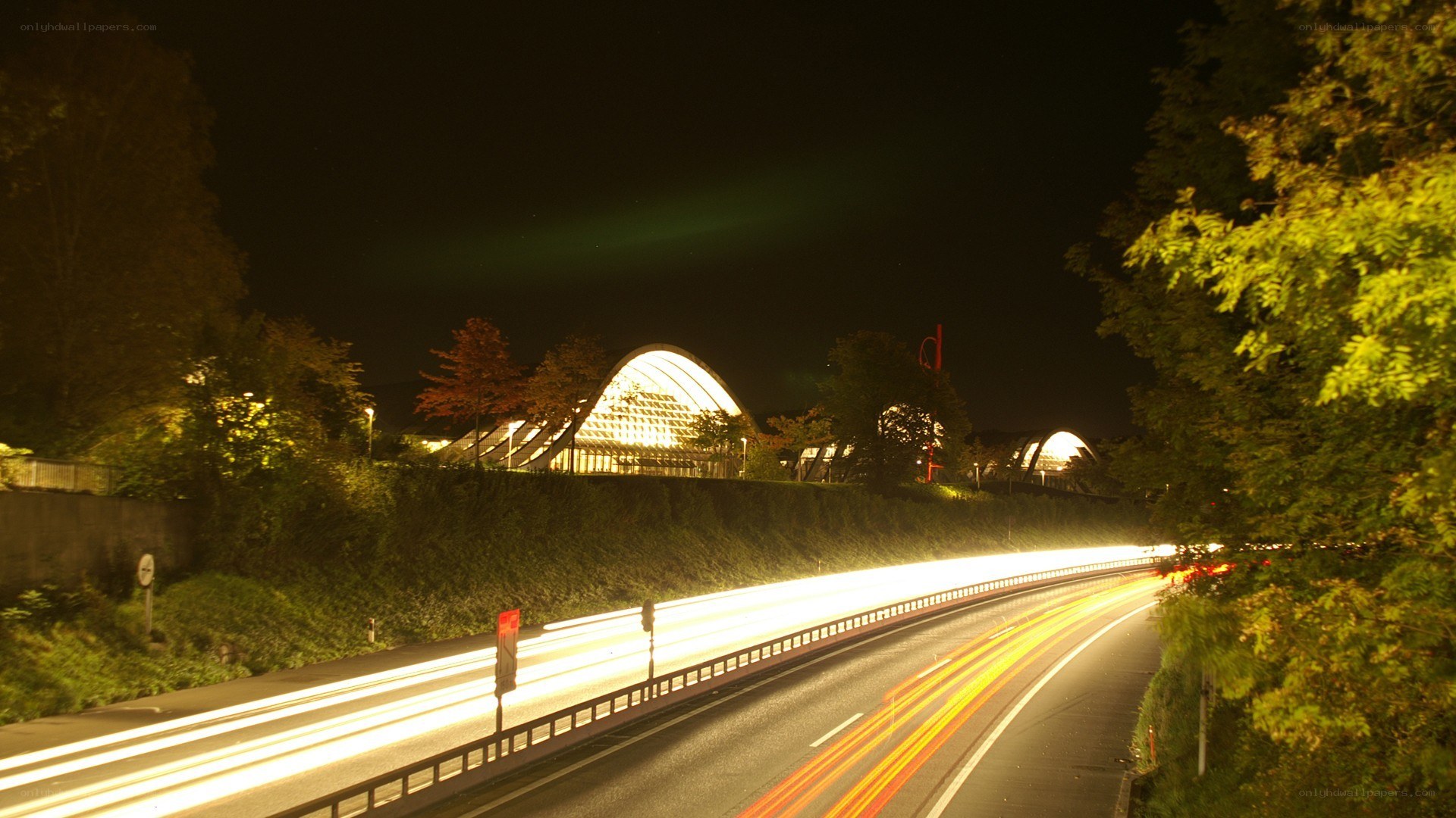 Nighttime highway with illuminated building