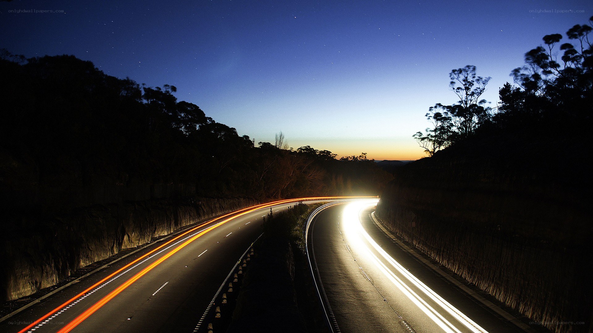 Nighttime highway with light trails