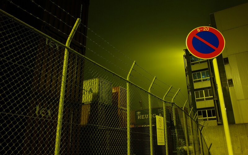 Nighttime industrial area with no parking sign