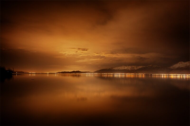 Nighttime lake with city lights