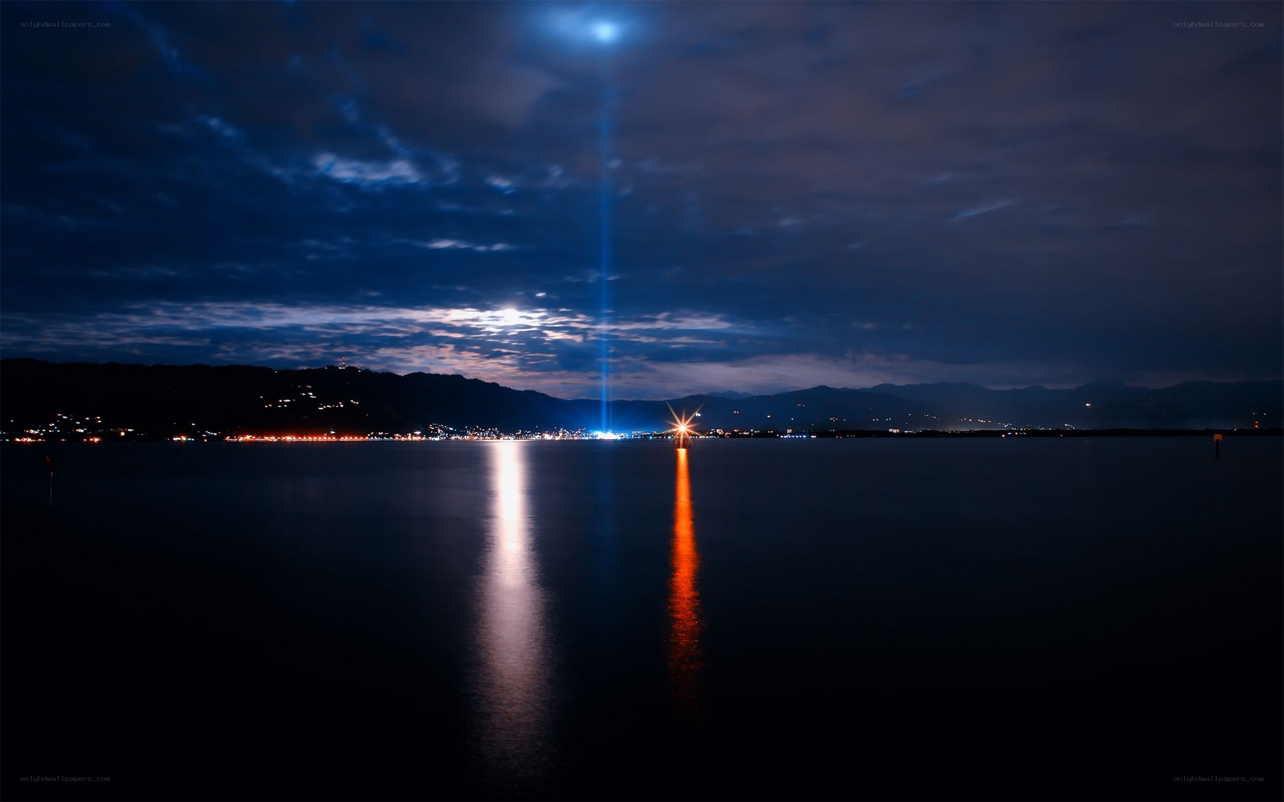 Nighttime lake with light beams