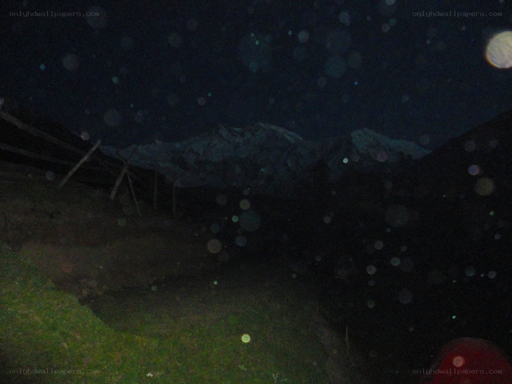 Nighttime mountain view with lens flare