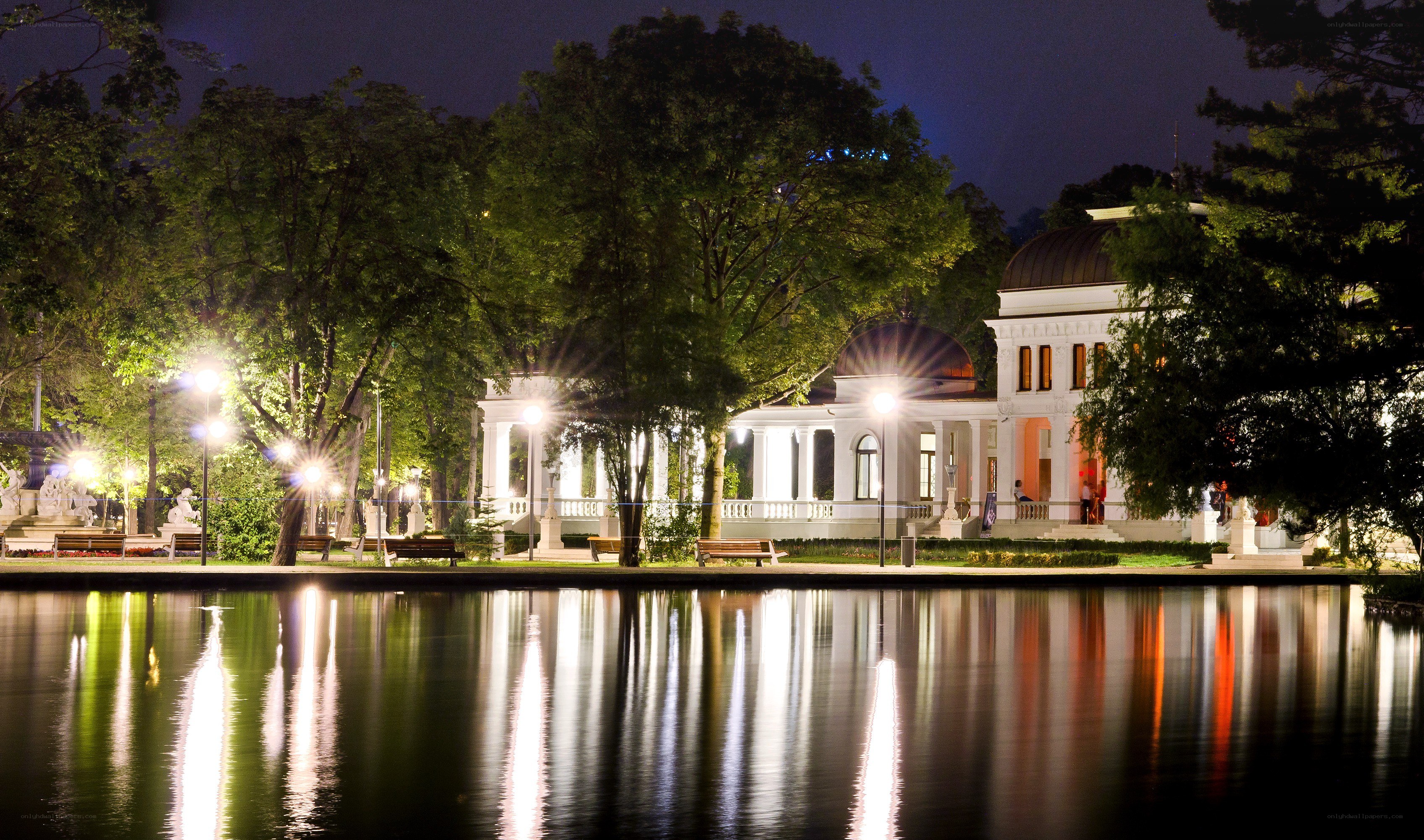 Nighttime park with illuminated buildings