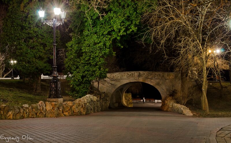 Nighttime park with stone bridge
