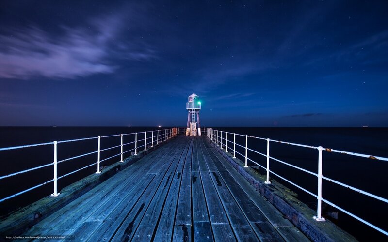 Nighttime pier with lighthouse