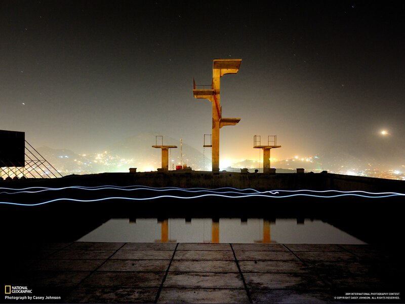 Nighttime pool with city lights