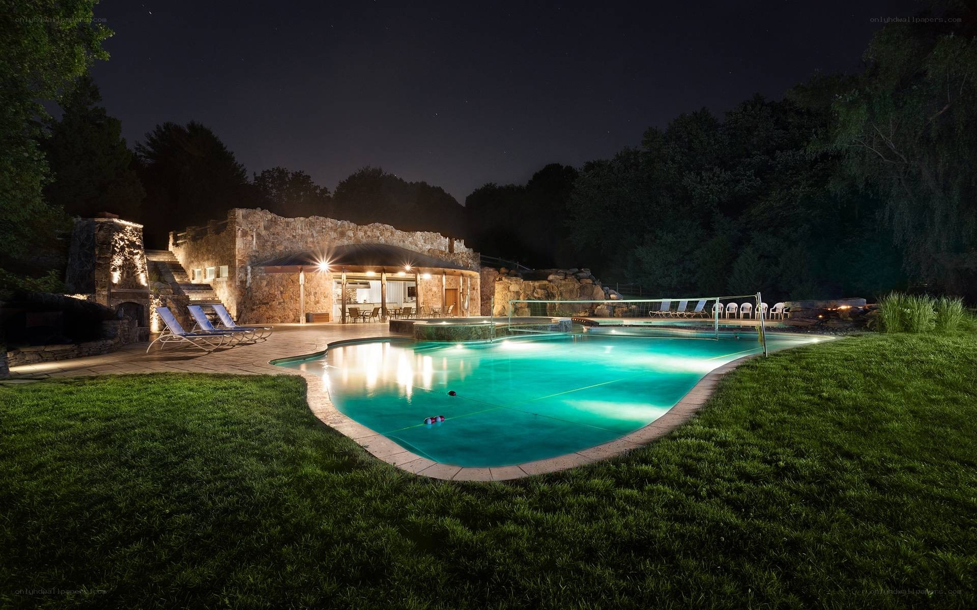 Nighttime pool with stone house