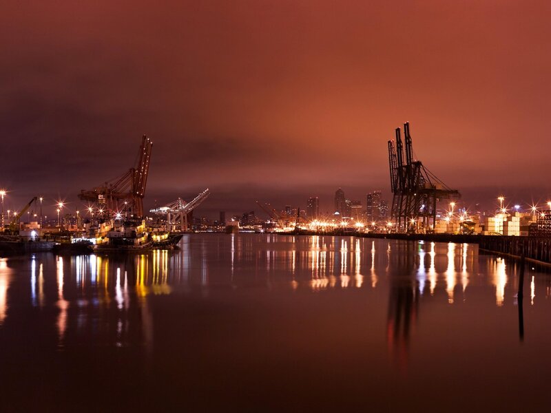 Nighttime port with city skyline