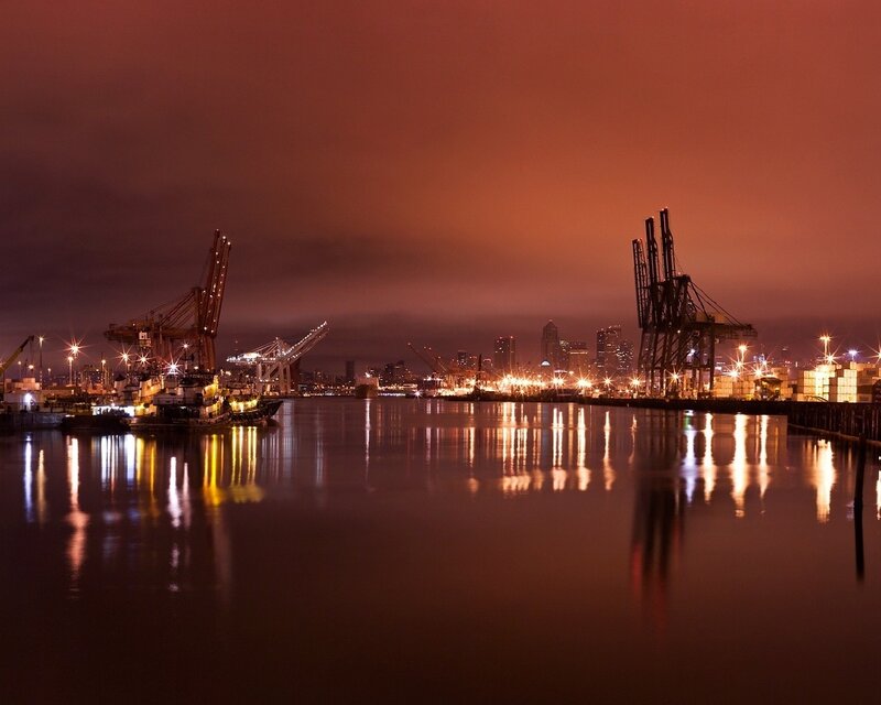 Nighttime port with city skyline