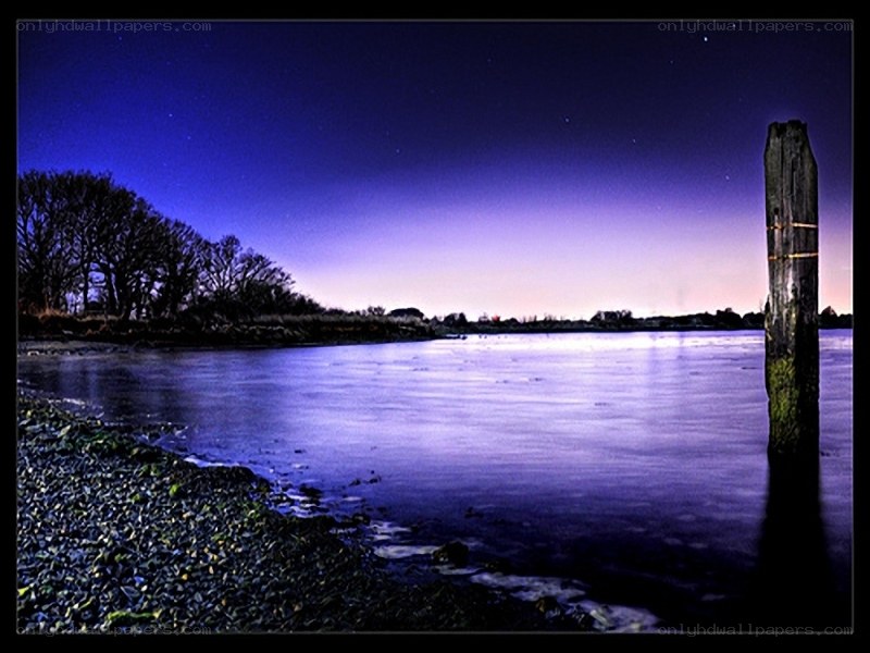 Nighttime river scene with wooden post