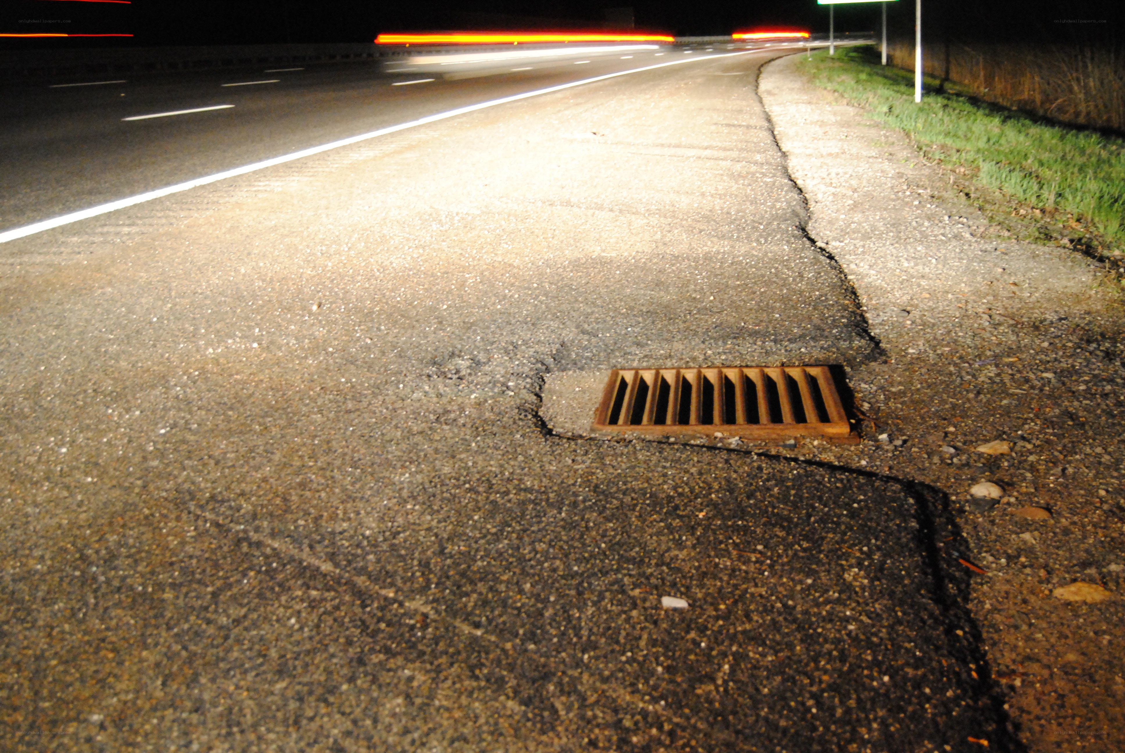 Nighttime road with drainage grate