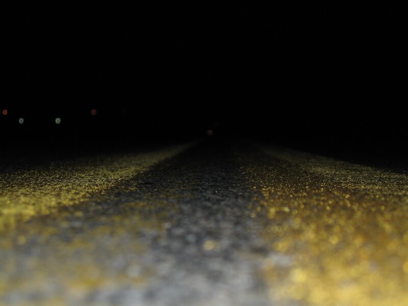 nighttime road with yellow line