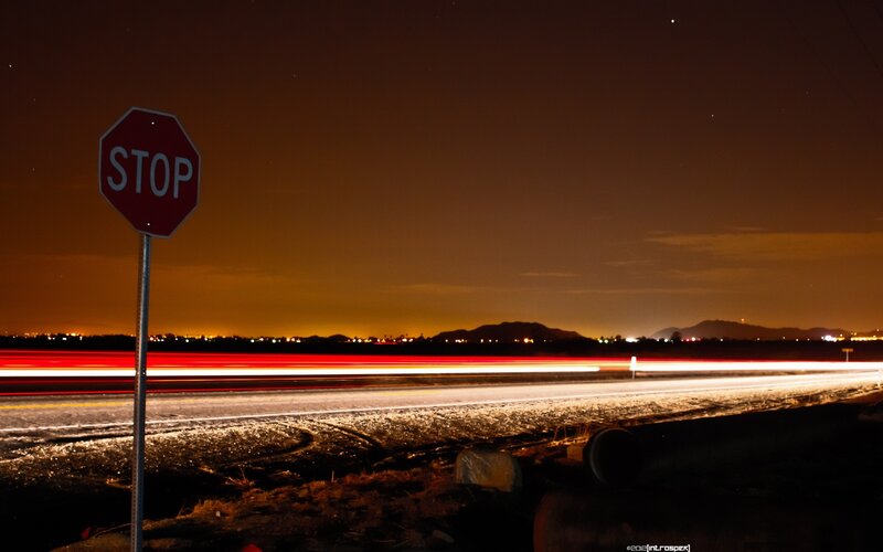 Nighttime stop sign with light trails
