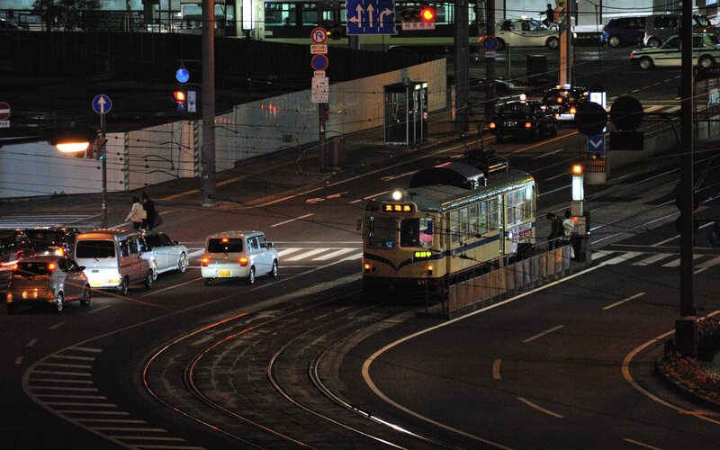 Nighttime street with tram and traffic