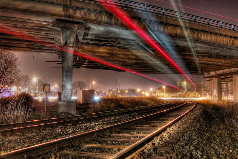 Nighttime train tracks under bridge