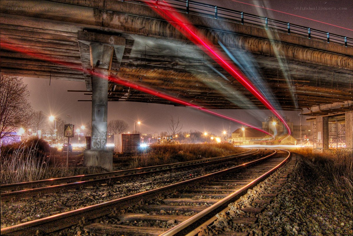 Nighttime train tracks under bridge