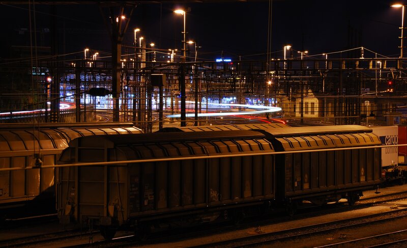 Nighttime train yard with light trails