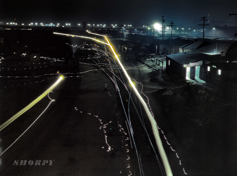 Nighttime train yard with light trails