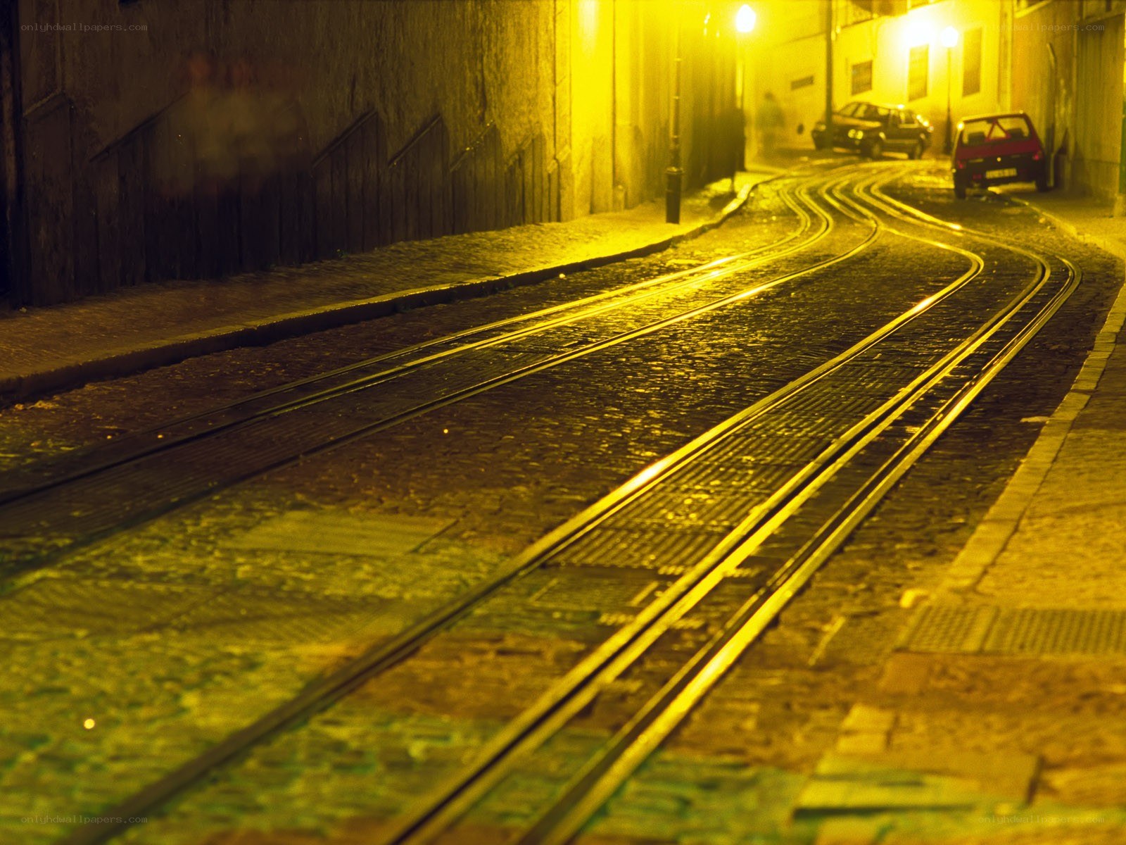 Nighttime tram tracks on a cobblestone street