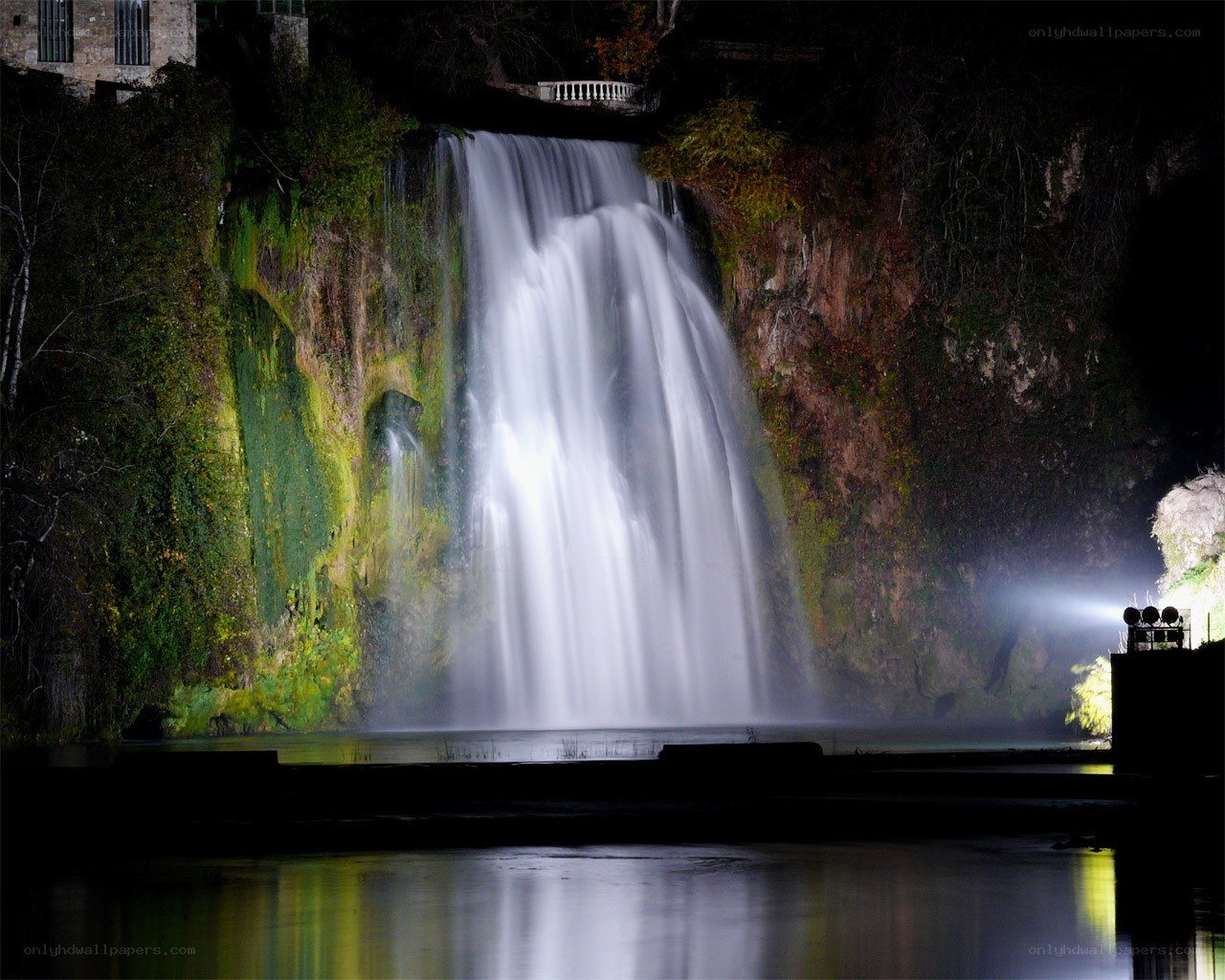 Nighttime waterfall illuminated