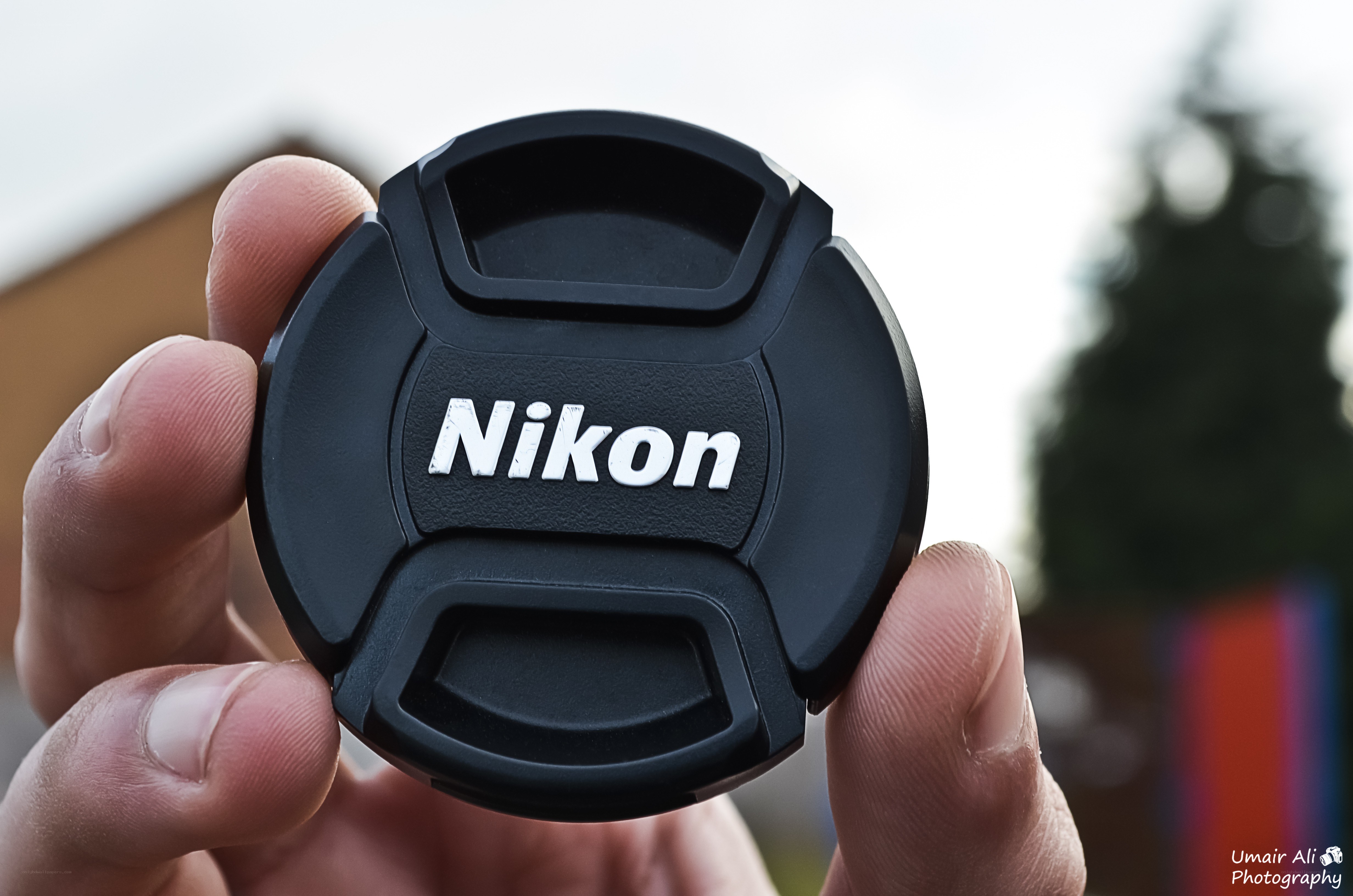 Nikon lens cap held in hand