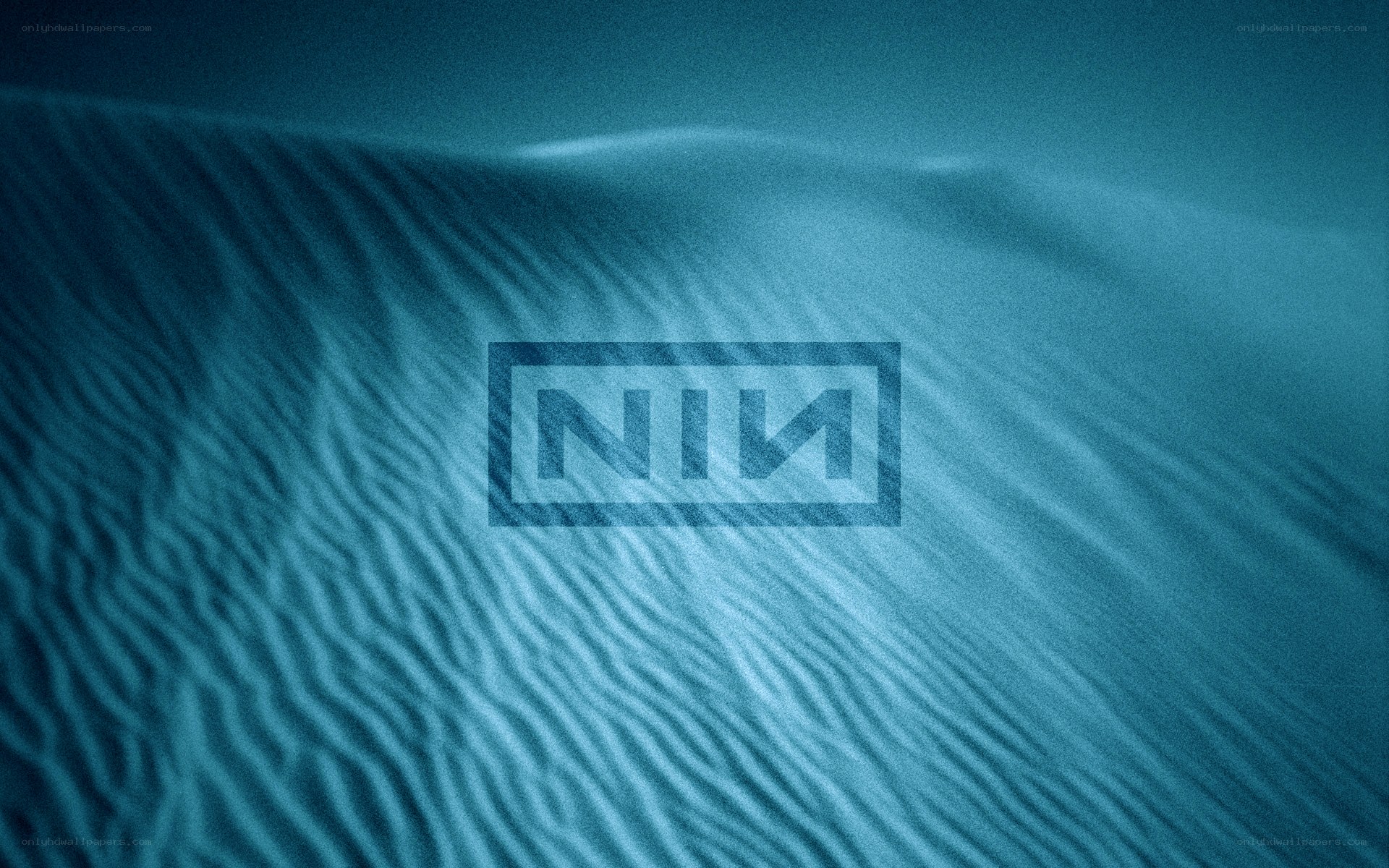NIN logo on sand dunes