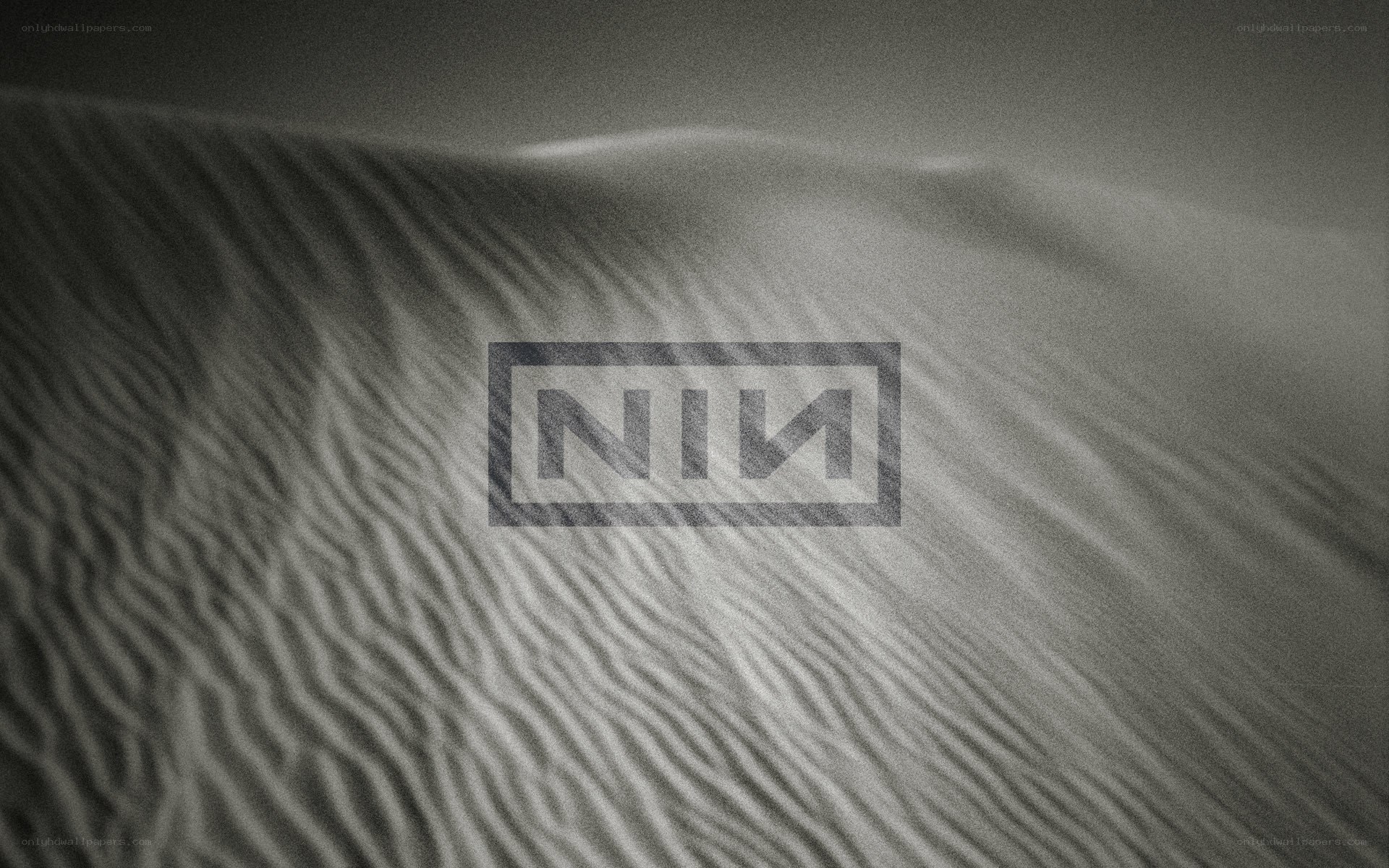 NIN logo on sand dunes