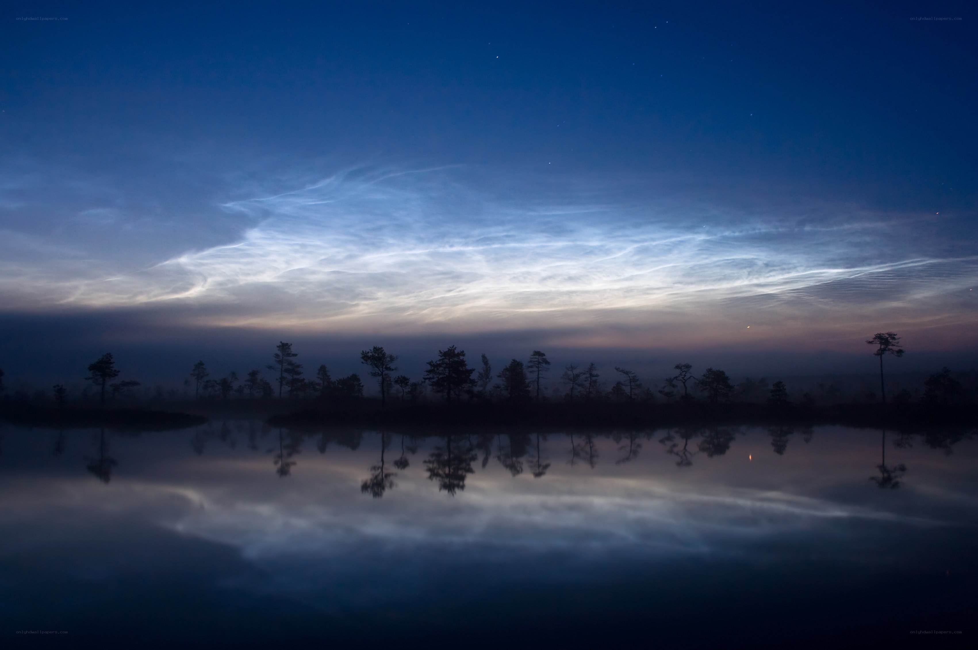 Noctilucent clouds over a lake
