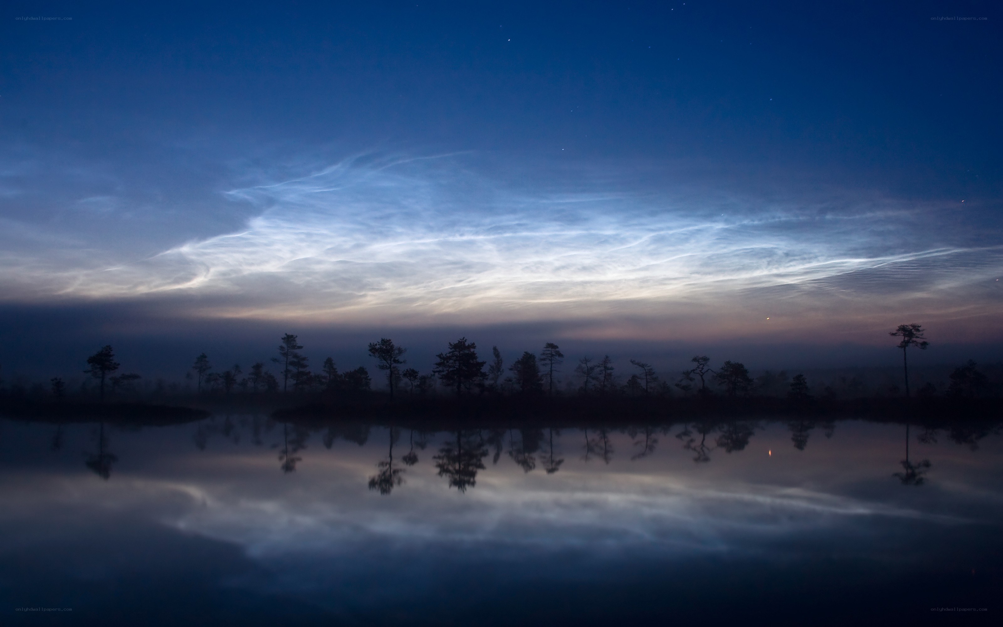 Noctilucent clouds over a lake
