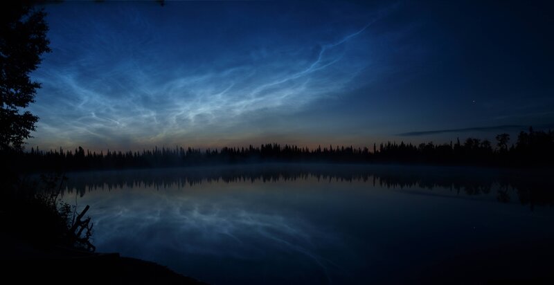 Noctilucent clouds over a lake